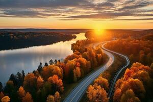 ai généré aérien vue de Montagne route dans forêt à le coucher du soleil dans l'automne. Haut vue de drone de route dans les bois. magnifique paysage avec chaussée dans collines, pin des arbres, vert prés photo