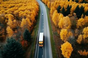 ai généré Arial vue de lourd un camion sur une étroit torsion route. l'automne coloré des arbres par le côtés de le route. photo