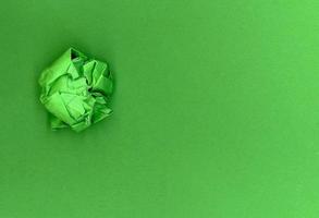 boule de papier vert sur fond de carton vert photo