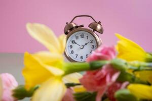 alarme l'horloge avec printemps fleurs. printemps temps, lumière du jour des économies concept, printemps vers l'avant photo