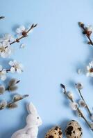 Pâques œufs, lapin et une fleur branche sur une bleu Contexte avec copie espace. photo