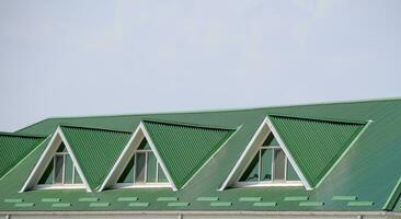 le maison avec Plastique les fenêtres et une vert toit de ondulé feuille. vert toit de ondulé métal profil et Plastique les fenêtres. photo