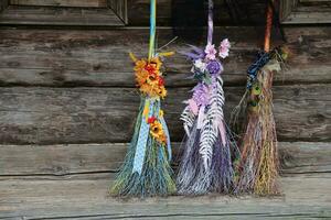 Trois différent balais de sorcières supporter à le vieux en bois cabane maison photo