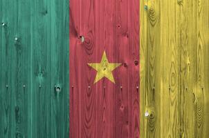 Cameroun drapeau représenté dans brillant peindre couleurs sur vieux en bois mur. texturé bannière sur rugueux Contexte photo