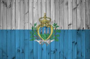 san marino drapeau représenté dans brillant peindre couleurs sur vieux en bois mur. texturé bannière sur rugueux Contexte photo