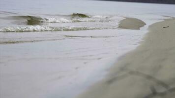 proche en haut pour rivière vagues sur une sablonneux rive. Stock images. petit vagues la lessive en haut une rivière rive avec lumière marron le sable dans une nuageux journée. photo