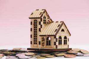 maison modèle pièces de monnaie avant fond rose