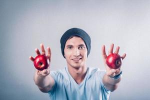 jeune homme tient des pommes dans ses mains