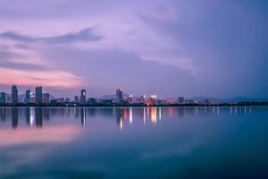 au crépuscule, le lac reflète la vue nocturne de la ville photo