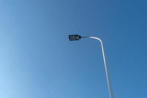 sous le ciel bleu, il y a des lampadaires dans la rue et les oiseaux s'arrêtent dessus photo