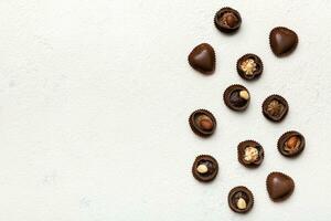 différent sortes de des chocolats sur coloré table fermer. Haut vue et plat allonger avec copie espace photo