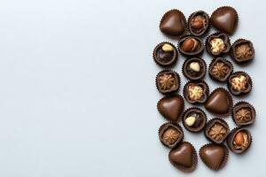 différent sortes de des chocolats sur coloré table fermer. Haut vue et plat allonger avec copie espace photo