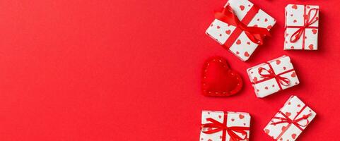vue de dessus des coffrets cadeaux et des coeurs textiles rouges sur fond coloré. concept de la saint-valentin avec espace de copie photo