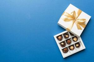 blanc boîte avec des chocolats des sucreries et d'or enregistrer. Haut vue avec copie espace photo