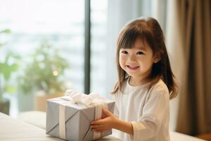 ai généré mignonne asiatique peu fille en portant cadeau boîte dans vivant pièce photo
