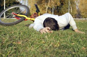 homme est tombée de le bicyclette dans le parc. photo
