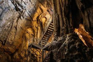 Prise de vue en contre-plongée d'un escalier installé à l'intérieur d'une grotte naturelle