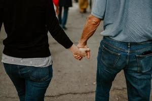 mise au point sélective d'un couple d'amoureux se tenant la main en marchant photo