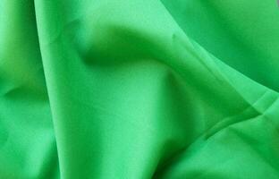 lumière vert en tissu avec grand plis abstrait Contexte. photo
