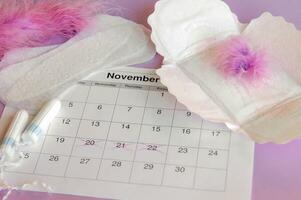 menstruel tampons et tampons sur menstruation période calendrier avec sur lilas Contexte. photo