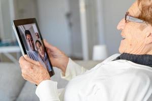 contenu femme âgée parlant sur le chat vidéo sur tablette photo