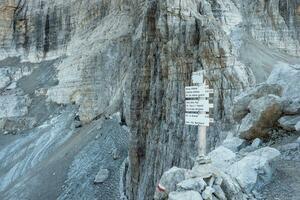trekking direction indicateurs. touristique chemins directions et Voyage temps montré sur une traditionnel direction panneaux à le Dolomiti montagnes, Italie photo