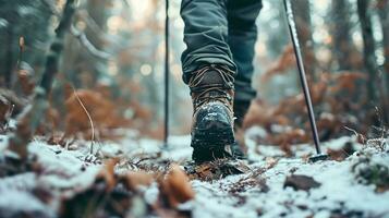 ai généré proche en haut de jambes de la personne dans randonnée des chaussures en marchant dans le hiver forêt photo