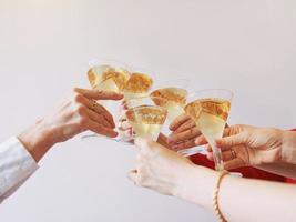nouvel an célébrant les mains avec des verres de vin mousseux blanc. noël, famille, amis, fête, concept du nouvel an photo