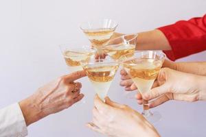 nouvel an célébrant les mains avec des verres de vin mousseux blanc. noël, famille, amis, fête, concept du nouvel an photo