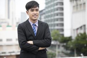 heureux bel homme d'affaires debout et souriant à l'extérieur photo