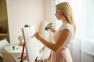 Jeune femme artiste avec palette et brosse La peinture abstrait image sur Toile à maison. art et la créativité concept. haute qualité photo