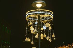 de fête rue décoration. composition avec guirlandes, d'or lumières contre le Contexte de le nuit ciel. Noël éclairage. photo