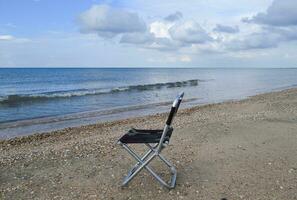 pliant chaise par le mer. commodité à le touristique. du repos par le mer. photo