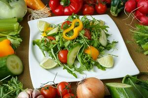 différent des légumes et salade avec feuille des légumes et Cerise tomates sur blanc plaque. photo