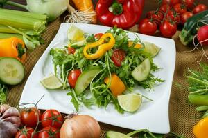 différent des légumes et salade avec feuille des légumes et Cerise tomates sur blanc plaque. photo