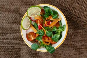 bol de Frais légume salade sur jute table tissu photo