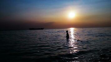 silhouette pêcheur pêche par filets dans le padma rivière, bangladesh photo