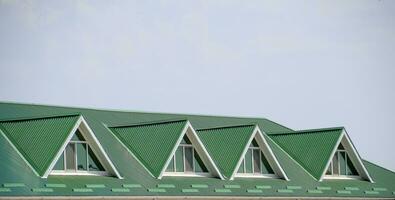 le maison avec Plastique les fenêtres et une vert toit de ondulé feuille. vert toit de ondulé métal profil et Plastique les fenêtres. photo