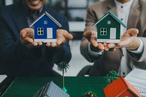 l'agent de courtage immobilier livre un échantillon d'une maison modèle au client, un contrat de prêt hypothécaire fait un bail et achète et vend une maison et contracte un concept de prêt hypothécaire d'assurance habitation photo