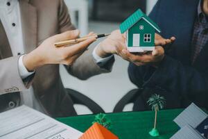 l'agent de courtage immobilier livre un échantillon d'une maison modèle au client, un contrat de prêt hypothécaire fait un bail et achète et vend une maison et contracte un concept de prêt hypothécaire d'assurance habitation photo