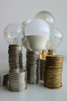 variété électrique ampoules et piles de argenté et laiton pièces de monnaie dans une Colonnes symbolisant énergie efficace photo