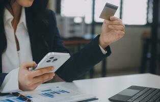 femmes en portant crédit carte et en utilisant les smartphones à maison.en ligne achats, l'Internet bancaire, boutique en ligne, paiement, dépenses argent, commerce électronique Paiement à le magasin, crédit carte, concept photo