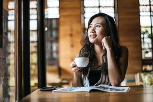 Belle femme lisant un magazine au café photo