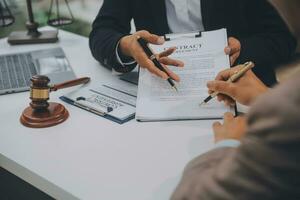 affaires et avocats discutant des documents contractuels avec une échelle en laiton sur le bureau au bureau. droit, services juridiques, conseils, image de concept de justice et de droit avec effet de grain de film photo