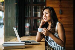 belle femme travaillant avec un ordinateur portable au café du café photo