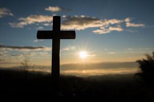 silhouette de croix catholique et lever de soleil photo