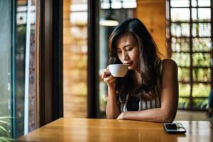 portrait, femme asiatique, sourire, se détendre, dans, café-restaurant, café photo