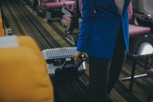 asiatique femelle voyageur en mettant bagage dans aérien casier sur avion pendant embarquement. photo