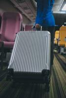 asiatique femelle voyageur en mettant bagage dans aérien casier sur avion pendant embarquement. photo