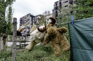 enfants jouets pendre sur une corde contre le Contexte de détruit brûlé Maisons dans Ukraine photo